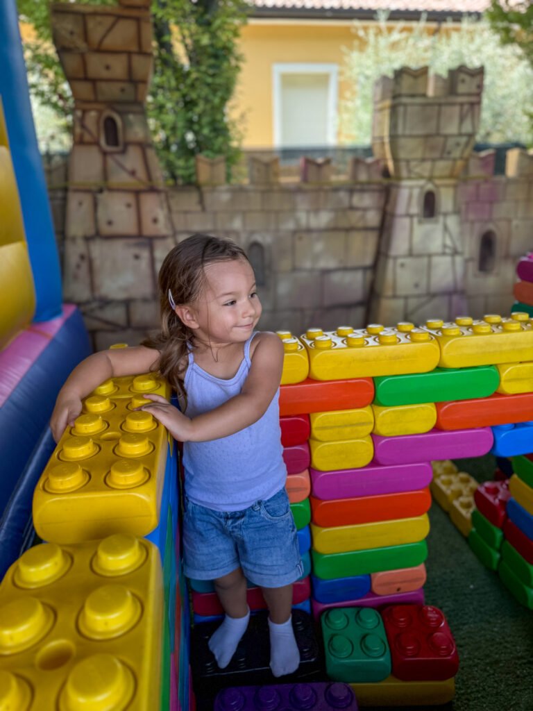 Bambina gioca con i mattoncini giganti al Play Village di Lazise